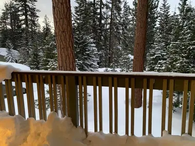 a balcony covered in snow with trees in the background at Mammoth Lakes Crestview Condo #50 in Mammoth Lakes