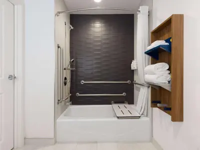 a bathroom with a shower with a white tub at Microtel Inn & Suites by Wyndham Tracy in Tracy