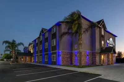 a hotel with blue lights in a parking lot at Microtel Inn & Suites by Wyndham Tracy in Tracy
