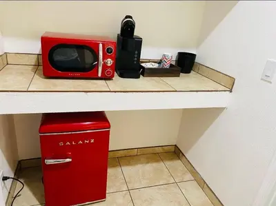 a red microwave sitting on a counter next to a refrigerator at Sequoia Village in Three Rivers
