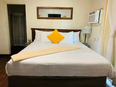 a bedroom with a large bed with two yellow pillows at Sequoia Village in Three Rivers