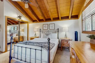 a bedroom with a bed and a wooden ceiling at Northstar Condo with Forested Views in Truckee