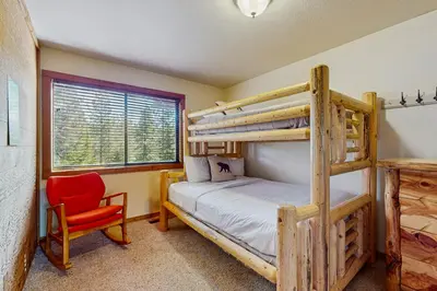 a bedroom with two bunk beds and a red chair at Northstar Condo with Forested Views in Truckee