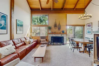 a living room with a couch and a table at Northstar Condo with Forested Views in Truckee