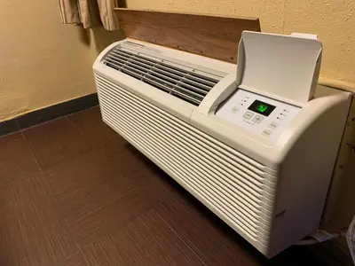 a white air conditioner sitting on the floor in a room at Tiki Lodge Hotel Modesto in Modesto