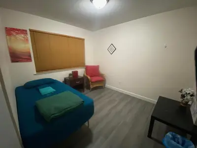 a living room with a blue couch and a red chair at WHOLE Family - Wolfgram in Sacramento