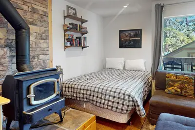 a bedroom with a bed and a stove at Bigwood 13 in Mammoth Lakes