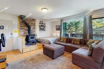 a living room with a couch and a tv and a bed at Bigwood 13 in Mammoth Lakes