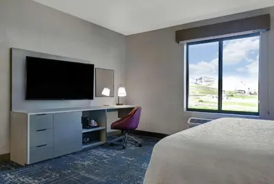 a hotel room with a television and a desk with a chair at Hampton Inn Patterson, Ca in Patterson