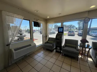 a room with two chairs and a television and windows at Fresno Inn in Fresno
