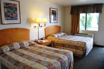 a hotel room with two beds and a window at Fresno Inn in Fresno