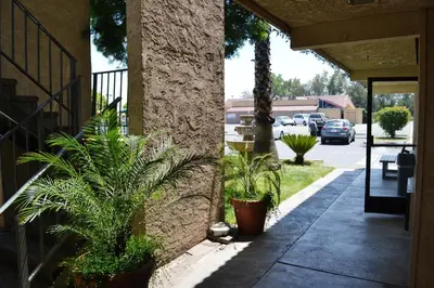 a sidewalk with potted plants next to a building at Fresno Inn in Fresno