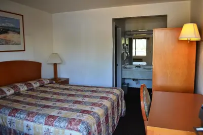 a hotel room with a bed and a sink at Fresno Inn in Fresno