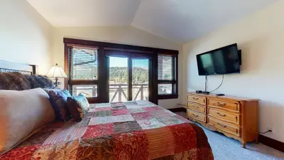 a bedroom with a bed and a tv on a dresser at Juniper Crest #7 Condo in Mammoth Lakes