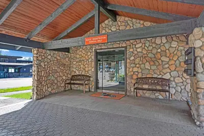 a stone building with two benches in front of a door at 3 Peaks Resort & Beach Club in South Lake Tahoe