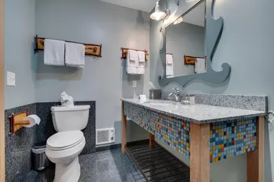 a bathroom with a toilet and a sink with a mirror at 3 Peaks Resort & Beach Club in South Lake Tahoe