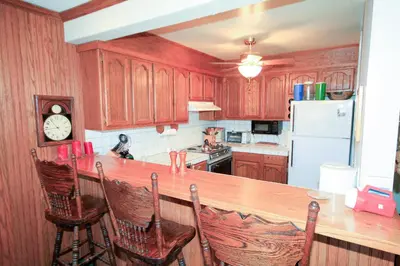 a kitchen with wooden cabinets and a counter with chairs at Mammoth Ski Racquet Club 115 in Mammoth Lakes