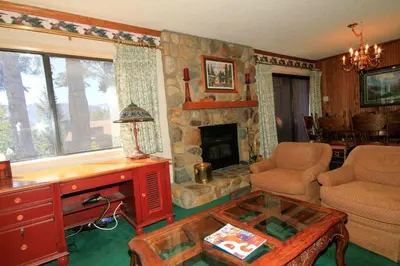 a living room with a stone fireplace and a table at Mammoth Ski Racquet Club 115 in Mammoth Lakes