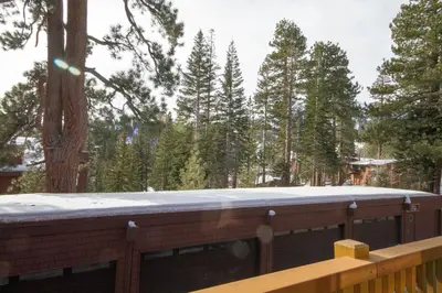 a wooden deck with a snow covered roof with a bench at Mammoth Ski Racquet Club 82 in Mammoth Lakes