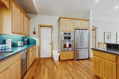 a kitchen with wooden cabinets and stainless steel appliances at Agate Road Retreat in Carnelian Bay