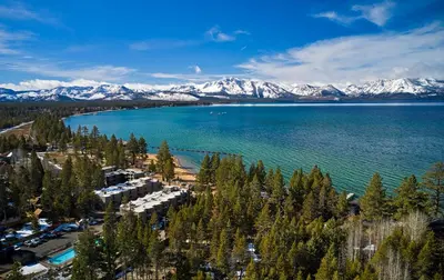 an aerial view of a lake with snow covered mountains at The Landing Resort and Spa in South Lake Tahoe