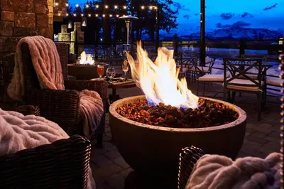a fire pit on a patio with chairs and a table at The Landing Resort and Spa in South Lake Tahoe