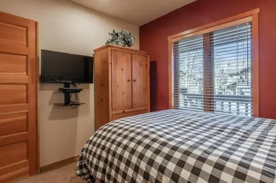 a bedroom with a bed and a tv and a window at Snowcreek V 756 in Mammoth Lakes