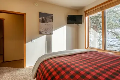 a bedroom with a bed and a tv and a window at Snowcreek V 756 in Mammoth Lakes