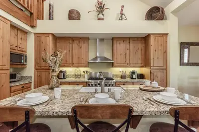 a kitchen with wooden cabinets and a granite counter top at Lodges 1132 - 3 bedroom Townhome on Golf Course in Mammoth Lakes