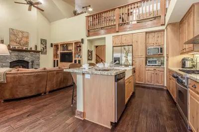 a large kitchen with wooden cabinets and a living room at Lodges 1132 - 3 bedroom Townhome on Golf Course in Mammoth Lakes