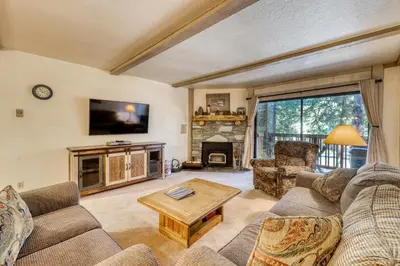 a living room with a couch and a tv and a table at The Summit 5 in Mammoth Lakes