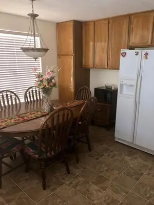 a kitchen with a table with chairs and a white refrigerator at Sequoia National Forest CabinM in Panorama Heights