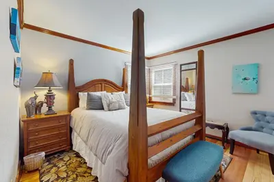 a bedroom with a large bed and a chair at Casual and Cute Cabin Near the Lake in Tahoe Vista