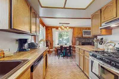 a kitchen with wooden cabinets and a dining room at Casual and Cute Cabin Near the Lake in Tahoe Vista