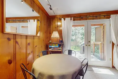 a dining room with a table and chairs and a window at Casual and Cute Cabin Near the Lake in Tahoe Vista