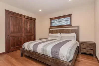 a bedroom with a bed with a wooden headboard and a window at Mountainside 4 in Mammoth Lakes