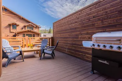 a patio with a grill and chairs and a table at Mountainside 4 in Mammoth Lakes