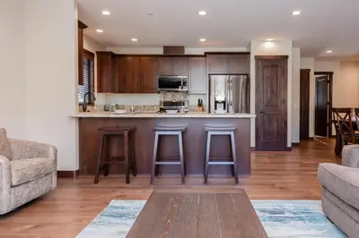 a kitchen with a bar with stools in a living room at Mountainside 5 in Mammoth Lakes