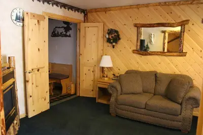a living room with a chair and a mirror at Tahoe Valley Lodge in South Lake Tahoe