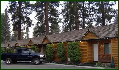 a truck parked in front of a log cabin at Tahoe Valley Lodge in South Lake Tahoe