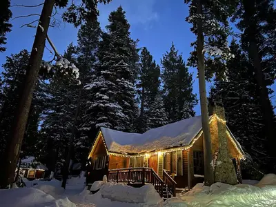 a log cabin in the snow at night at Tahoma Meadows - Sugar Pine Cabin in Tahoma