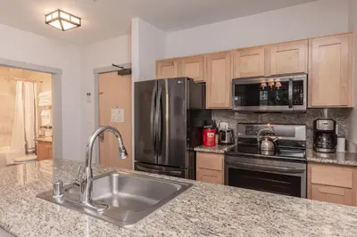 a kitchen with a sink and a stainless steel refrigerator at Juniper Springs Lodge #238 in Mammoth Lakes