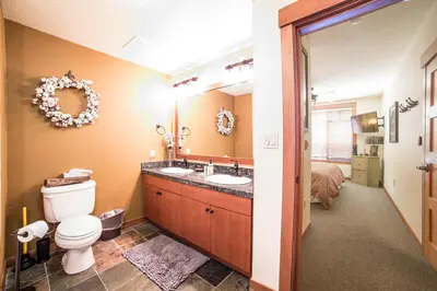 a bathroom with a toilet and a sink and a bed at White Mountain Lodge #2329 in Mammoth Lakes