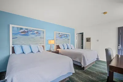 two beds in a hotel room with blue walls at Bluebird Day Inn & Suites in South Lake Tahoe