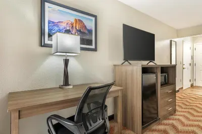 a room with a desk with a television and a chair at Best Western Plus Sonora Oaks Hotel and Conference Center in Sonora