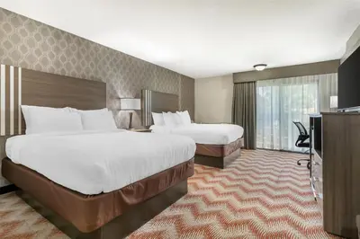 a hotel room with two beds and a television at Best Western Plus Sonora Oaks Hotel and Conference Center in Sonora