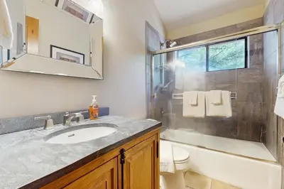 a bathroom with a sink and a toilet and a mirror at Sophisticated Northstar Mountain Retreat in Truckee