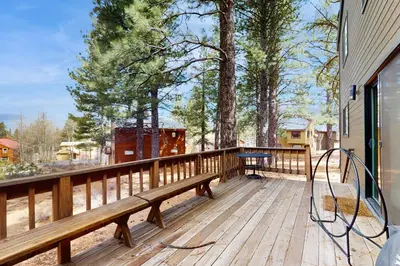 a wooden deck with a bench and a table on it at Sophisticated Northstar Mountain Retreat in Truckee
