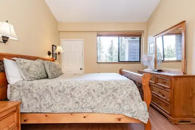 a bedroom with a bed and a dresser and two windows at Summit B- # 257 in Mammoth Lakes