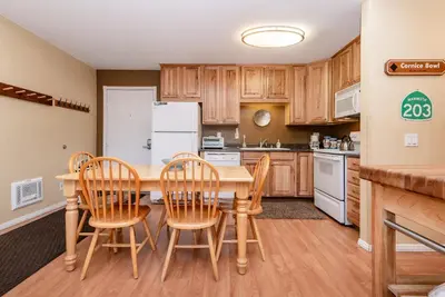 a kitchen with wooden cabinets and a table and chairs at Summit B- # 257 in Mammoth Lakes